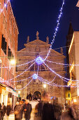 ITALY, Venice. Christmas decorations hangs over Campo San Moise along Calle Larga XXII Marzo. The Chiesa di San Moise is in the center and the front of the Hotel Bauer is on the right.