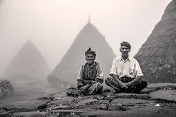 INDONESIA, Flores, two leaders of the Wae Rebo Village sit in front of their residences called Mbaru Niang