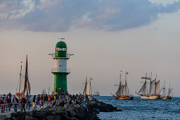 Sailboats in Warnemünde with onlookers and lighthouse to the Hanse Sail, Warnemünde, Rostock, Baltic Sea coast, Mecklenburg-Vorpommern, Germany