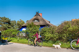 Cyclists in front of Blaue Scheune, Vitte, Hiddensee island, Mecklenburg-Western Pomerania, Germany