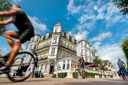 Cyclists in front of Hotel Ahlbecker Hof, Ahlbeck, Usedom island, Mecklenburg-Western Pomerania, Germany