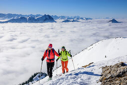 Zwei Frauen auf Skitour steigen zum Hinteren Sonnwendjoch auf, Nebelmeer im Tal, Hinteres Sonnwendjoch, Bayerische Alpen, Tirol, Österreich