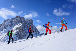 Mehrere Personen auf Skitour steigen zum Medalges auf, Geislergruppe im Hintergrund, Medalges, Naturpark Puez-Geisler, UNESCO Weltnaturerbe Dolomiten, Dolomiten, Südtirol, Italien