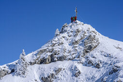 Three persons backcountry skiing standing at summit of Wildalpjoch, Wildalpjoch, Bavarian Alps, Upper Bavaria, Bavaria, Germany