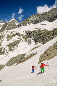 Man and woman hiking ascending through snow at Giro di Monviso, Giro di Monviso, Monte Viso, Monviso, Cottian Alps, France