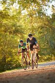 Zwei junge Männer fahren auf Gravel bikes über Feldweg, Münsing, Bayern, Deutschland