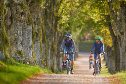 Young  woman on touring bike, young man on touring eBike on tour, Muensing, bavaria, germany