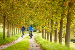 Young  woman on touring bike, young man on touring eBike on tour, Muensing, bavaria, germany