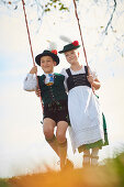 Junge und Mädchen auf Schaukel, Trachtenverein Seeröserl Ammerland Münsing , Ammerland Münsing, Bayern, Deutschland