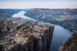 hikers sit on edge around Preikestolen and enjoy view at Lysefjord, Rogaland Province, Norway, Scandinavia, Europe