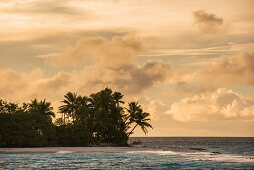 Die späte Nachmittagssonne, leichte Wolken und eine tief liegende, von Palmen bedeckte Insel schaffen eine traumhafte Atmosphäre, Likiep Atoll, Ratak-Kette, Marshallinseln, Südpazifik