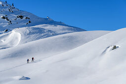 Man and woman on ski tour ascend to Regenfeldjoch, Regenfeldjoch, Kitzbüheler Alpen, Tyrol, Austria