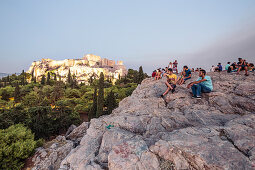 Besucher am Areopag, Marshügel, genießen die Abendstimmung und den Blick zur Akropolis, Athen, Griechenland
