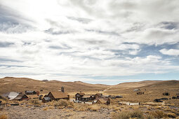 View of the ghost town of Bodie under a cloudy sky in the Eastern Sierra, California, USA.
