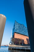 Die Elbphilharmonie, eingerahmt von zwei riesigen Pollern, Hafencity, Hamburg, Deutschland