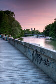 Pedestrian path between Isar and Auer Mühlbach south of Maximiliansbrücke with a view of the cable bridge and the tower of the Müller'schen Volksbad, Munich, Bavaria, Germany