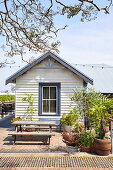 Table with bench on terrace in front of wooden house, NSW, Australia