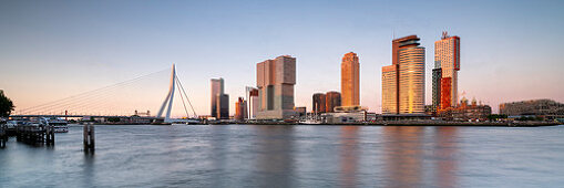 Abendlicher Blick über die Neue Maas auf die Erasmusbrücke und die Skyline am Cruise Terminal in Rotterdam, Niederlande