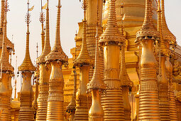 Shwe Inn Dein Pagoda - stupa field with golden stupas in the evening light at Inle Lake, Nyaung Shwe, Myanmar
