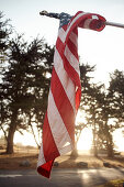 Verwickelte Amerikanische Flagge im Abendlicht auf einem Parkplatz bei Big Sur am Highway 1, Kalifornien, USA.