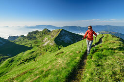 Frau beim Wandern steigt über Wiesenrücken zum Monte Pavione auf, Monte Pavione, Belluneser Dolomiten, Venezien, Venetien, Italien