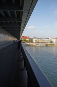 Promenade auf der Brücke des Slowakischen Nationalaufstandes (slowakisch offiziell Most SNP) mit Donau und Häuserfront, Bratislava, Slowakei