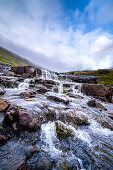Stream and small waterfall on Sreymoy island with cloudy sky.
