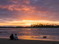 Paar bei Sonnenuntergang am Strand mit Palmen, Insel Boipeba, Bahia, Brasilien, Südamerika