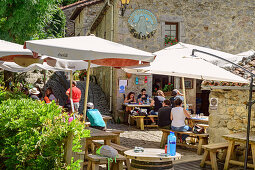 Mehrere Personen sitzen auf Terrasse einer Bar, Bulnes, Nationalpark Picos de Europa, Kantabrisches Gebirge, Asturien, Spanien
