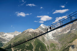 Zwei Personen gehen über Kuonen-Hängebrücke, längste Hängebrücke der Welt, Weißhorn im Hintergrund, Europaweg, Randa, Walliser Alpen, Wallis, Schweiz