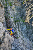 Frau beim Bergsteigen klettert durch Schrofenwand, Sonntagshorn, Chiemgauer Alpen, Chiemgau, Oberbayern, Bayern, Deutschland