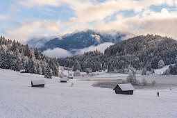 Blick über den gefrorenen Geroldsee auf schneebedeckte Landschaft, Krün, Bayern, Deutschland.