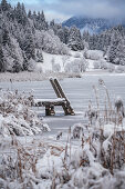 Blick über den gefrorenen Geroldsee auf schneebedeckte Landschaft, Krün, Bayern, Deutschland.