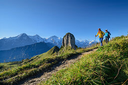 Man and woman hiking with Gumihorn in the middle distance, Eiger, Mönch and Jungfrau in the background, from Schynigen Platte, Grindelwald, Bernese Oberland, UNESCO World Natural Heritage Swiss Alps Jungfrau-Aletsch, Bernese Alps, Bern, Switzerland