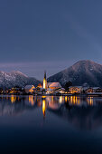 View over the wintry Tegernsee to the village of Rottach-Egern with the church Sankt Laurentius, Bavaria, Germany.