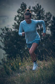 Young woman runs in the evening mood at Falkenstein, Allgäu, Bavaria, Germany