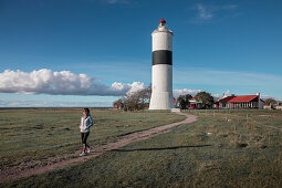 Frau am Leuchtturm Långe Jan im Süden der Insel Öland von Schweden bei blauem Himmel\n