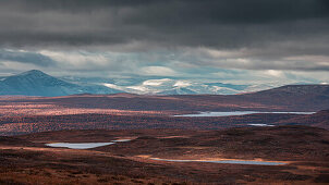 Mountain landscape with lakes and snow-covered peaks in Pieljekaise National Park in autumn in Lapland in Sweden