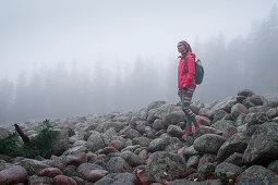 Woman hikes through stone field in Skuleskogen National Park in eastern Sweden