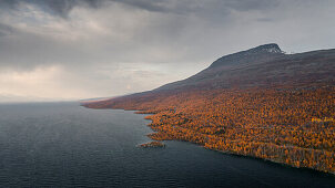 Landschaft mit Bergen und See im Stora Sjöfallet Nationalpark im Herbst in Lappland in Schweden von oben\n