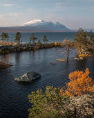 Landschaft mit verschneiten Bergen des Sarek Nationalparks und See im Stora Sjöfallet Nationalpark im Herbst in Lappland in Schweden\n