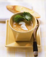 Pumpkin soup garnished with sour cream and coriander