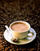 A cup of coffee on coffee beans