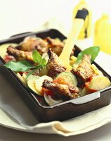 Chicken pieces on vegetable gratin in roasting dish