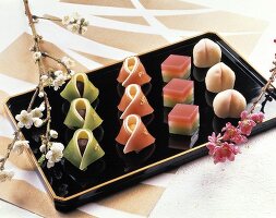 Japanese sweets on black platter; flowers