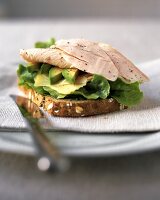 Sandwich with turkey breast, avocado, cheese and lettuce