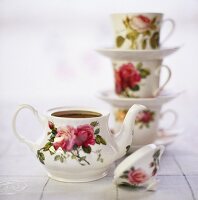Teekanne und Teetassen mit romantischer Rosendekoration