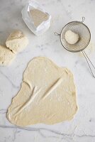 Dough and flour on marble slab