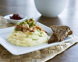 Mashed potato with small pieces of meat and black bread