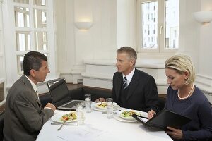 Geschäftsleute halten eine Besprechung beim Essen